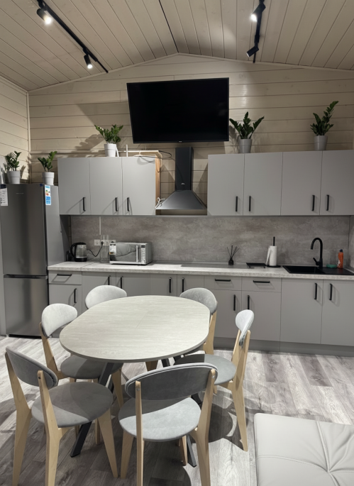 add_a_large_55_inch_black_flat_screen_TV_above_the_range_hood__near_the_ceiling_in__subject_1_